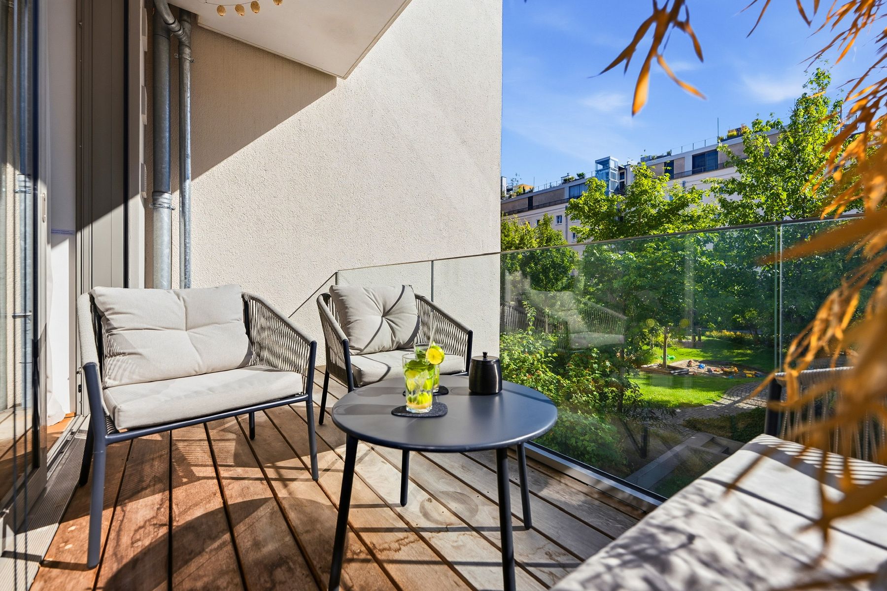 Sonniger Balkon mit Sitzecke über dem Innenhof